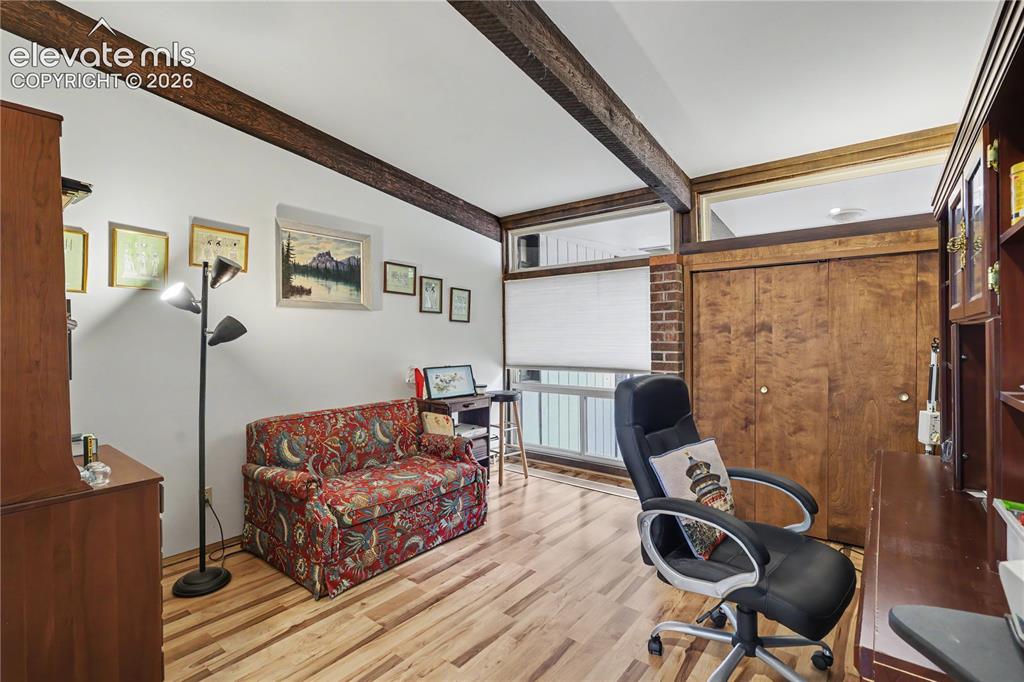 Image 28 of 50: Room featuring exposed wood ceiling beams, light wood-finish flooring, and 