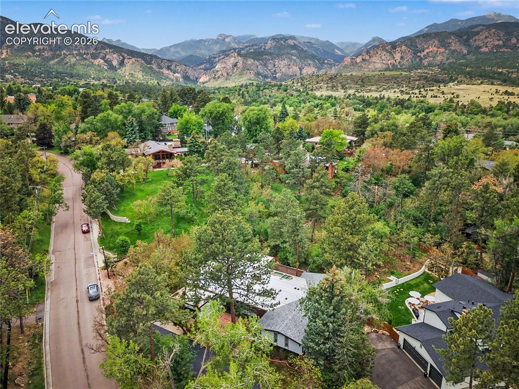 Image 3 of 50: Expansive aerial perspective showcasing mountainous terrain and a verdant l