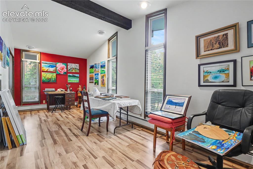 Image 39 of 50: Room featuring wood-finish flooring, a vaulted ceiling with exposed beam, a
