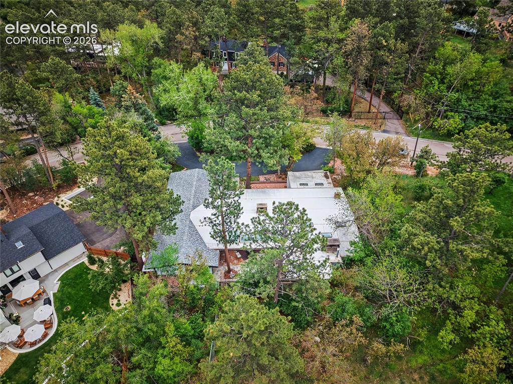 Image 4 of 50: Aerial property view showcasing a residence with a gray shingle roof and su