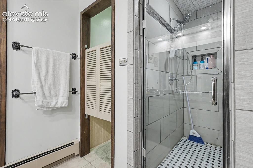 Image 41 of 50: Glass-enclosed shower featuring a tiled surround, recessed shower niche, an