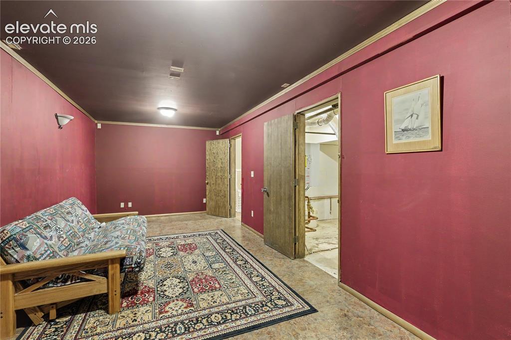 Image 42 of 50: Finished room featuring two doors, wall sconces, and overhead lighting