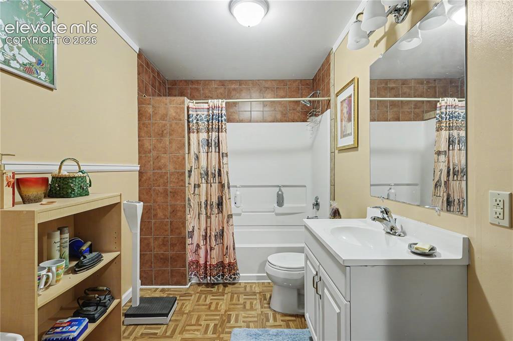 Image 43 of 50: Bathroom featuring a single vanity with an integrated sink, a large wall-mo