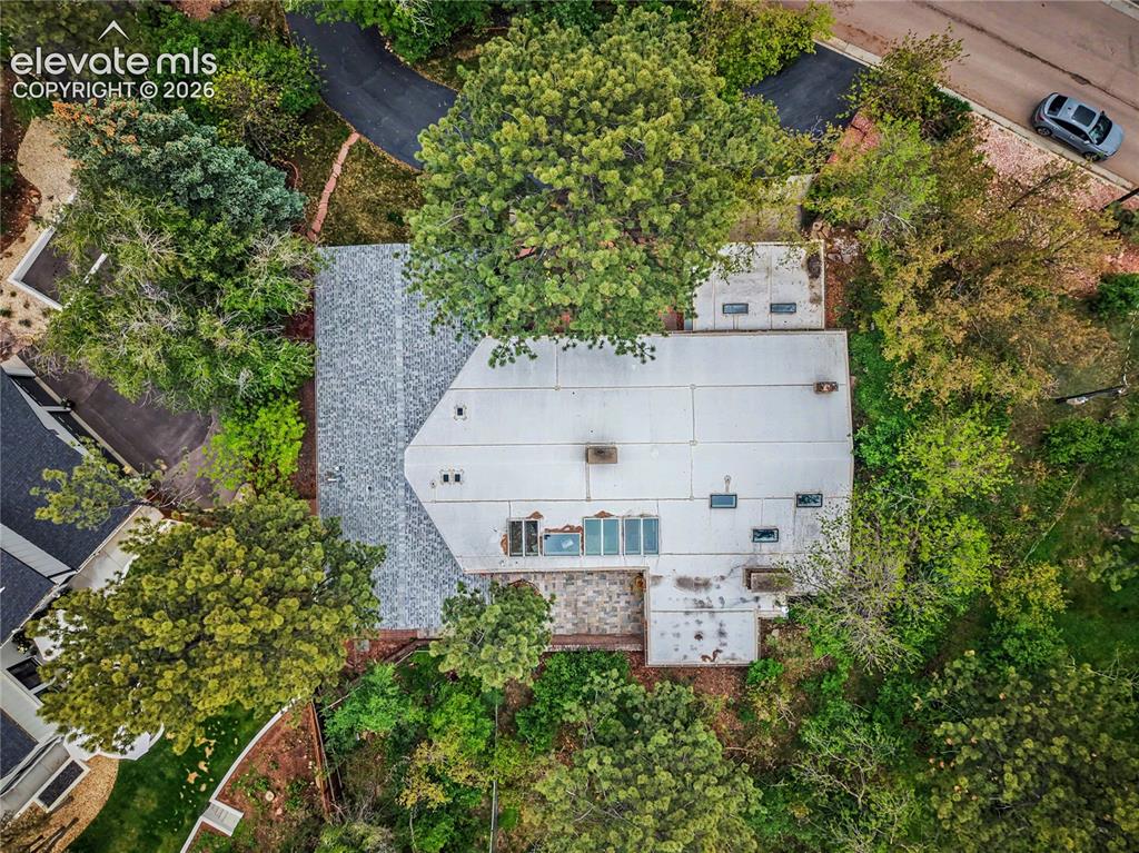 Image 5 of 50: Property featuring a mixed-material roof, including shingle and flat sectio