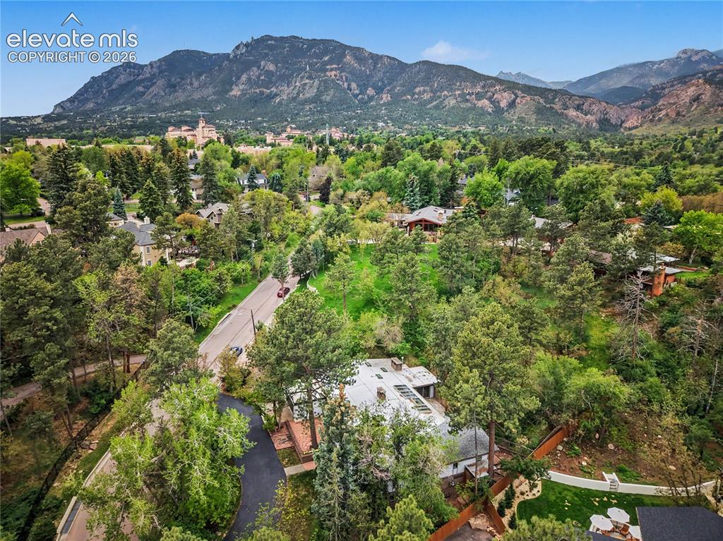 Image 6 of 50: Expansive property featuring a asphalt driveway, mature trees, mountain bac