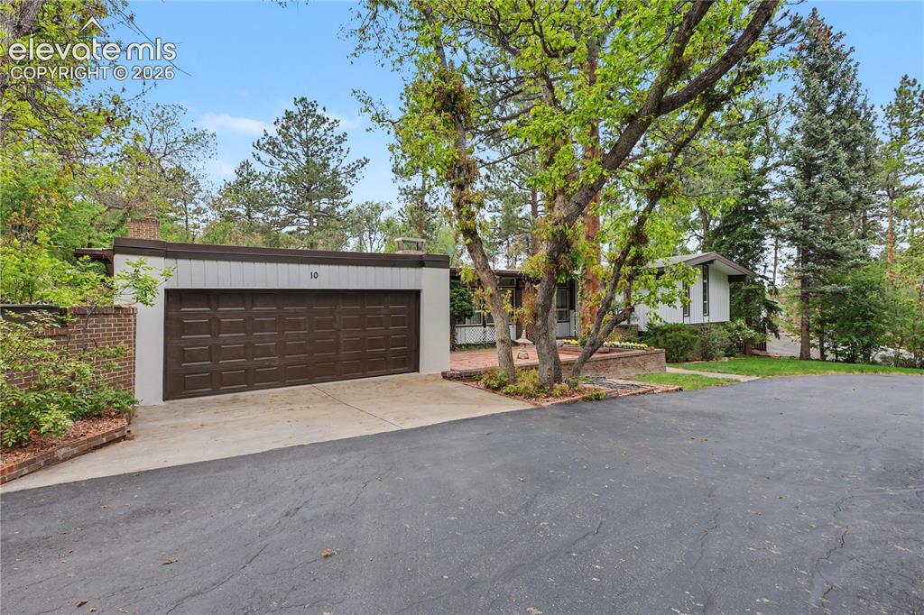 Image 7 of 50: Mid-century modern residence featuring an integrated three-car garage with 
