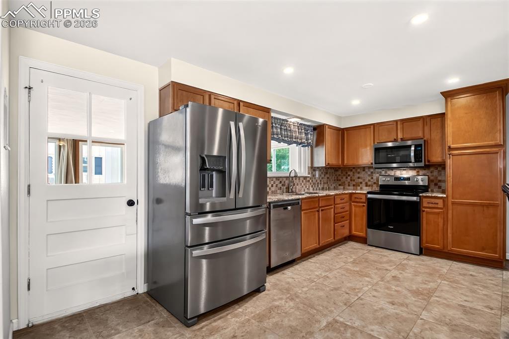 Image 10 of 39: Stainless Appliances,, Custom Tile Flooring, Walk-Out To Sun Room