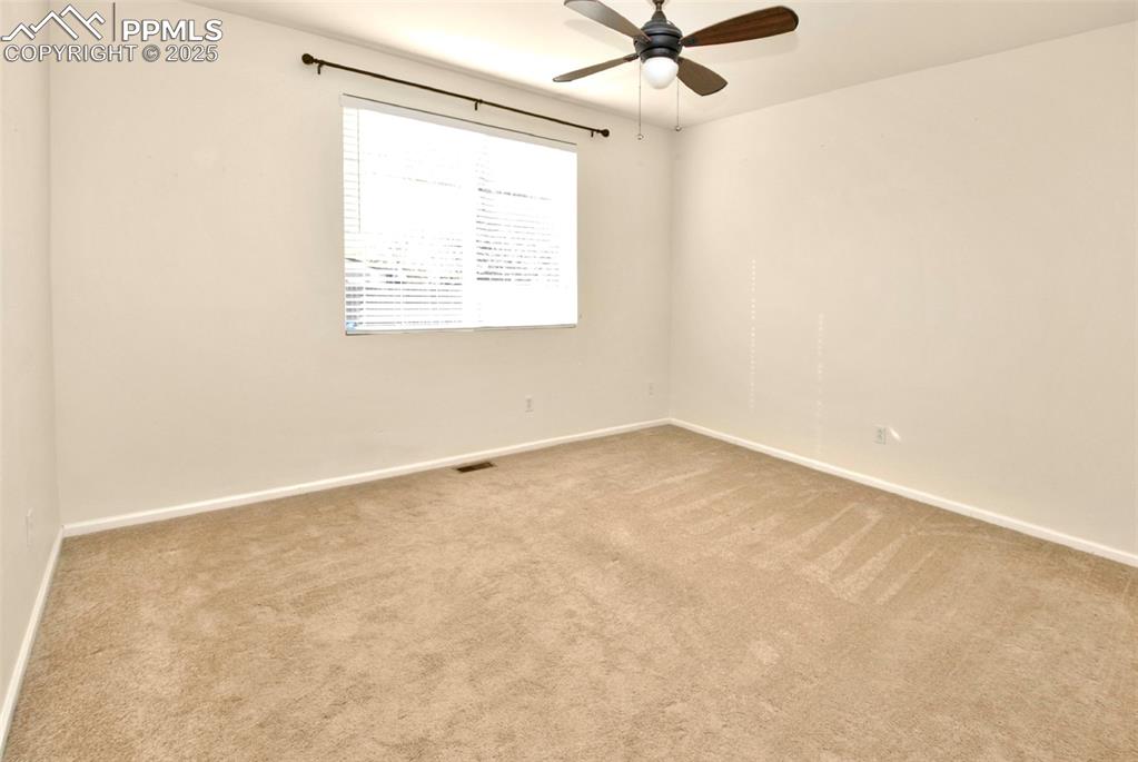 Image 12 of 27: Empty room featuring carpet flooring and a ceiling fan