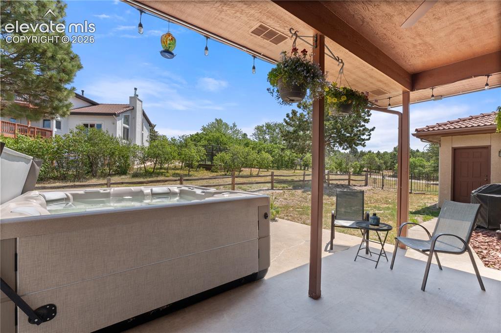 Image 29 of 30: The back patio is the perfect place to relax and unwind on the covered pati