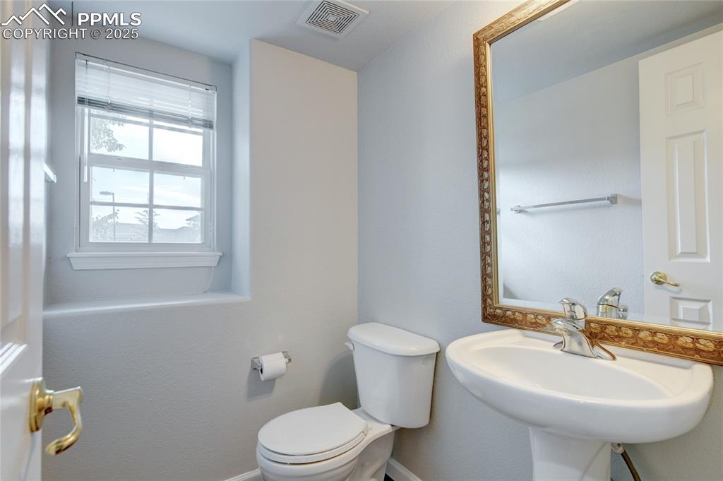 Image 10 of 23: Half bathroom with toilet and a sink