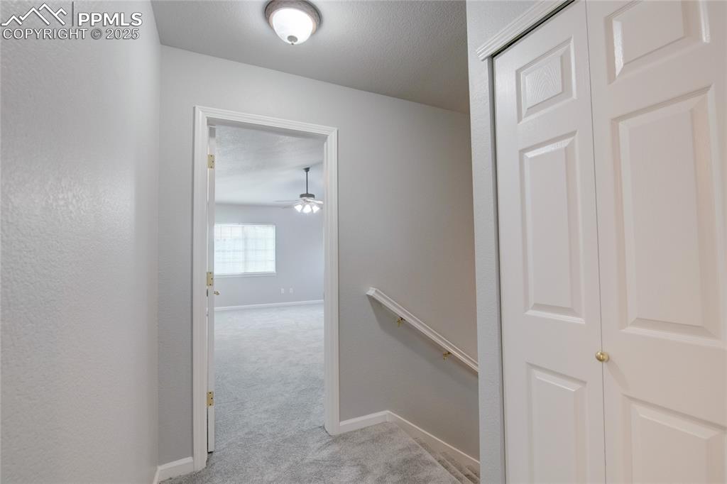 Image 11 of 23: Hall with an upstairs landing and light carpet