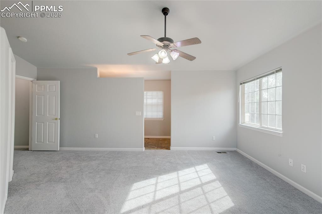 Image 14 of 23: Empty room with a ceiling fan, carpet floors, and a smoke detector
