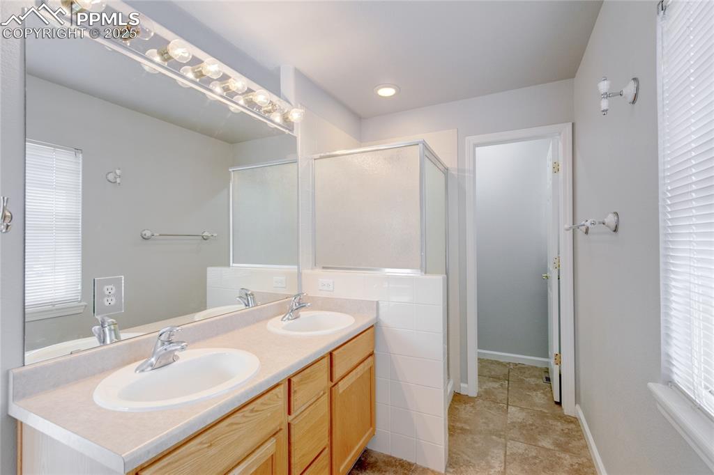 Image 15 of 23: Full bathroom featuring double vanity, a stall shower, and recessed lightin