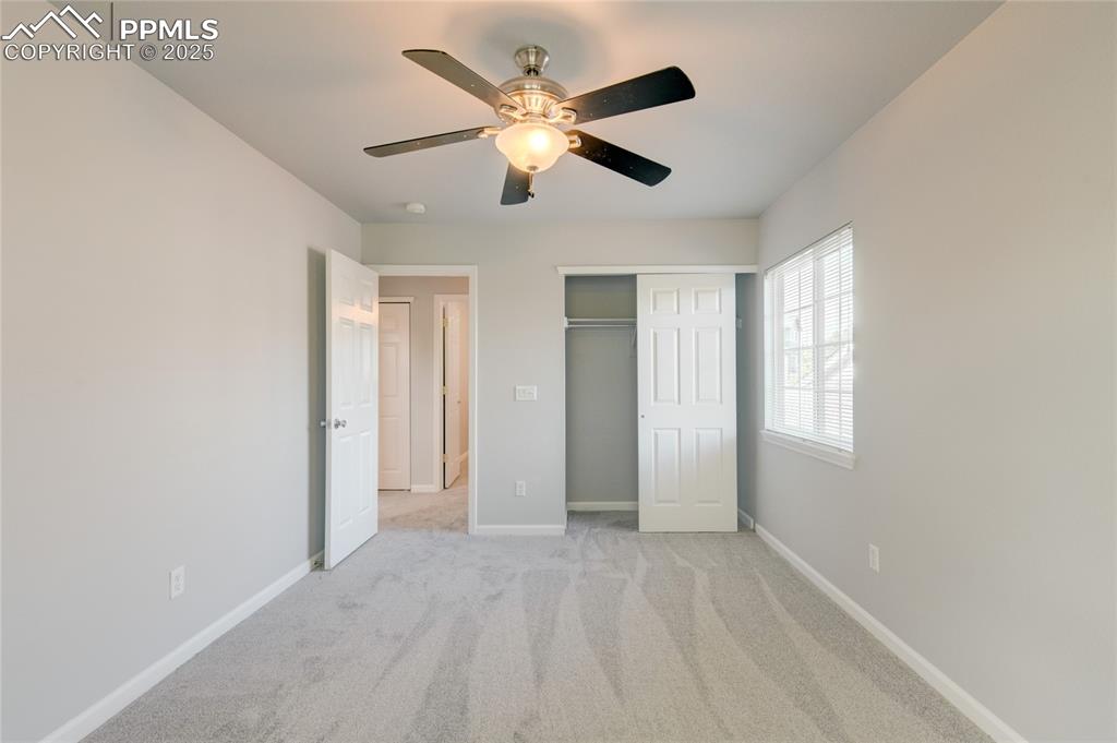 Image 18 of 23: Unfurnished bedroom with light carpet, a closet, and ceiling fan