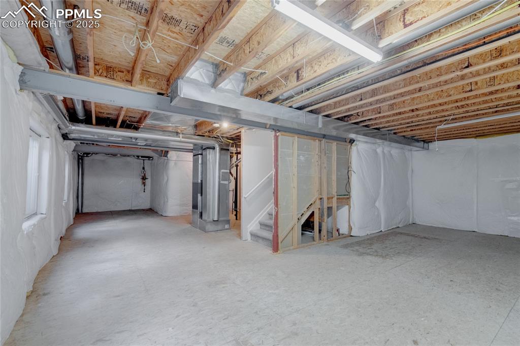 Image 20 of 23: Basement featuring heating unit and stairs