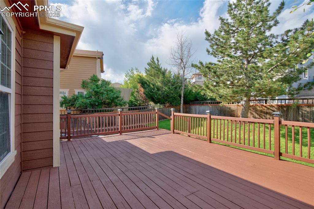 Image 21 of 23: Wooden deck with a fenced backyard
