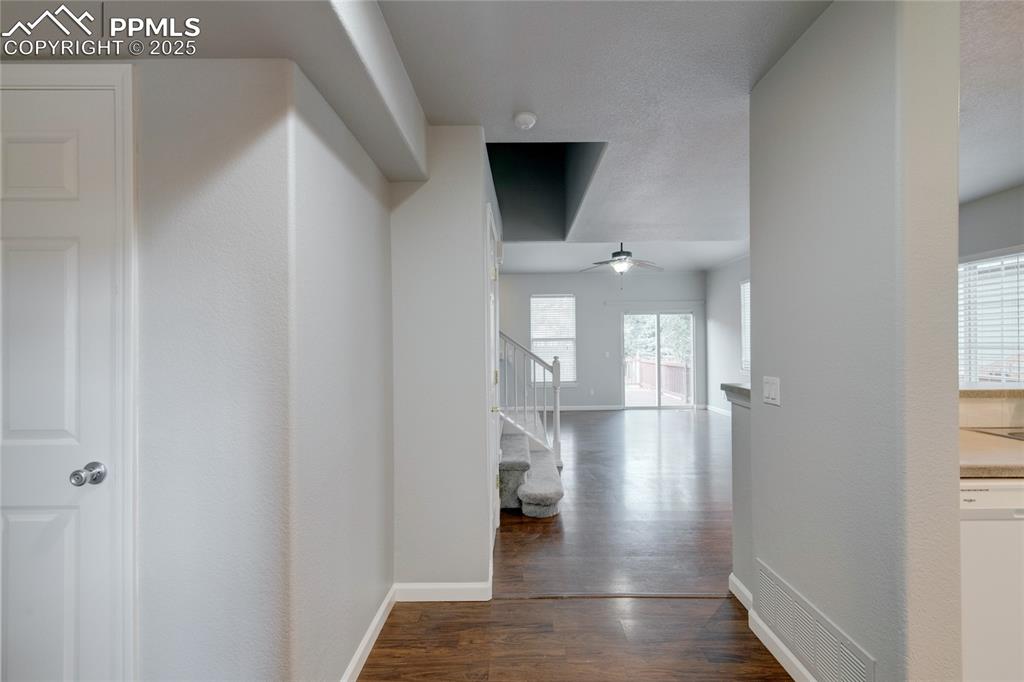 Image 3 of 23: Hall with dark wood finished floors and stairway