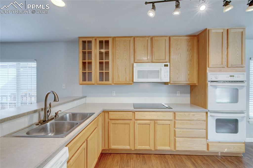 Image 7 of 23: Kitchen featuring white appliances, light brown cabinetry, light wood-style