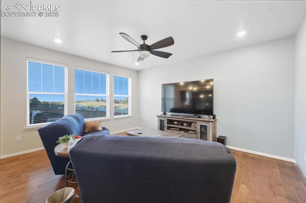 Image 13 of 35: Living room with wood finished floors, recessed lighting, and a ceiling fan