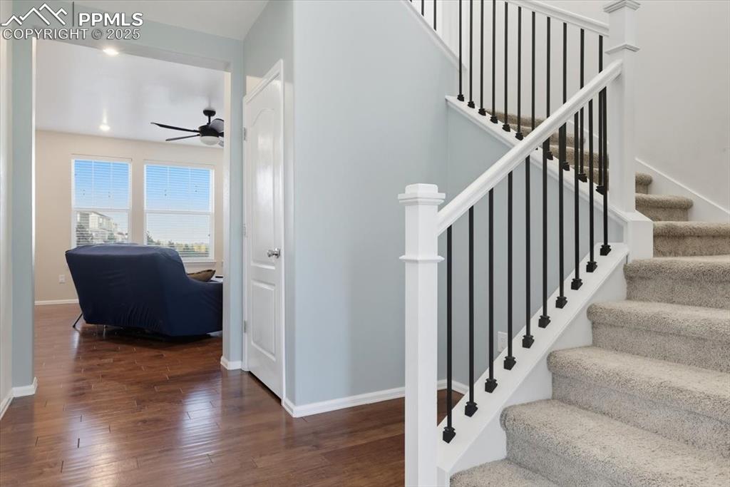 Image 15 of 35: Stairs featuring wood finished floors and ceiling fan