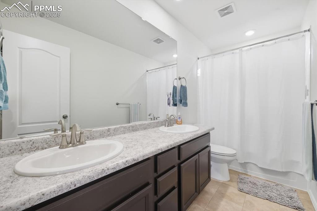 Image 17 of 35: Bathroom featuring shower / bath combination with curtain, light tile patte