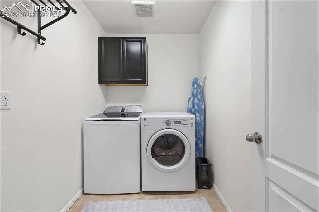 Image 19 of 35: Laundry area with cabinet space and washer and clothes dryer