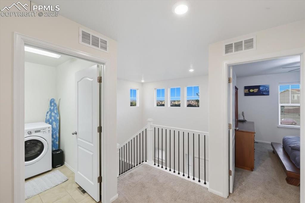 Image 20 of 35: Corridor featuring washer / dryer, an upstairs landing, recessed lighting,