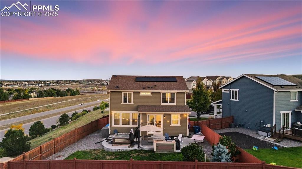Image 28 of 35: Back of property at dusk featuring an outdoor hangout area, a patio area, a