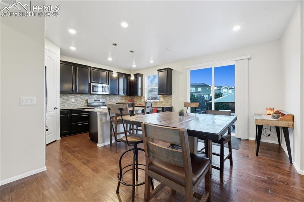 Image 5 of 35: Dining area with dark wood-style flooring and recessed lighting