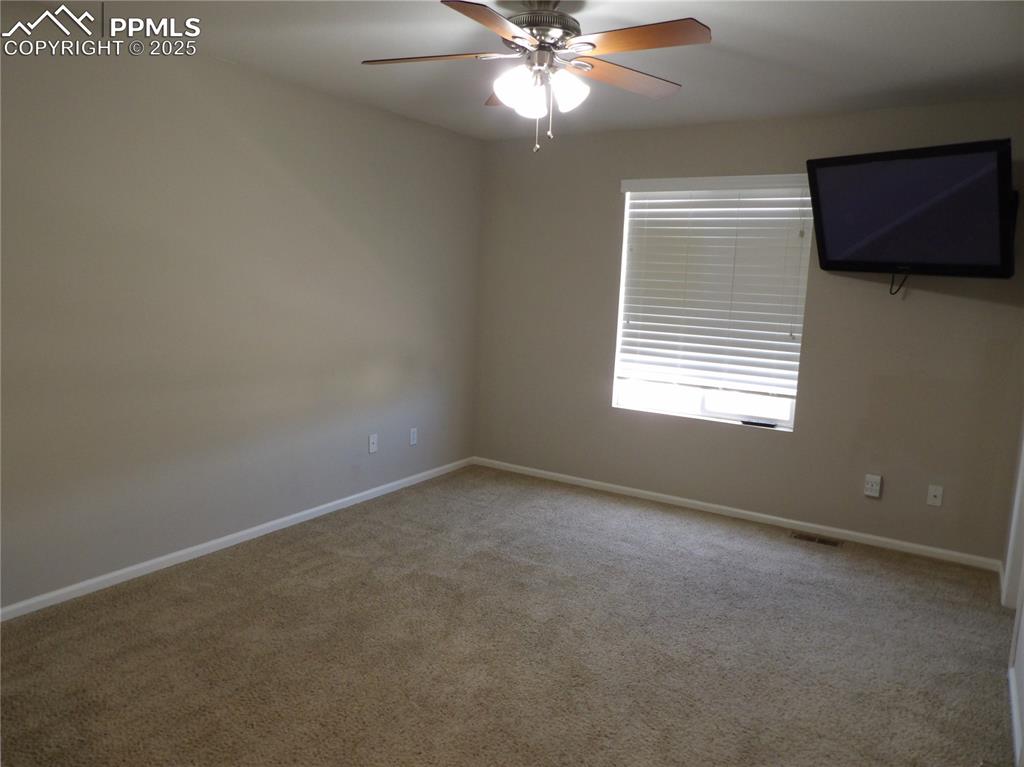 Image 14 of 23: Carpeted empty room featuring a ceiling fan and baseboards