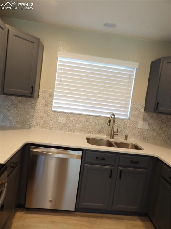 Image 8 of 23: Kitchen with dishwasher, light wood finished floors, gray cabinets, and lig