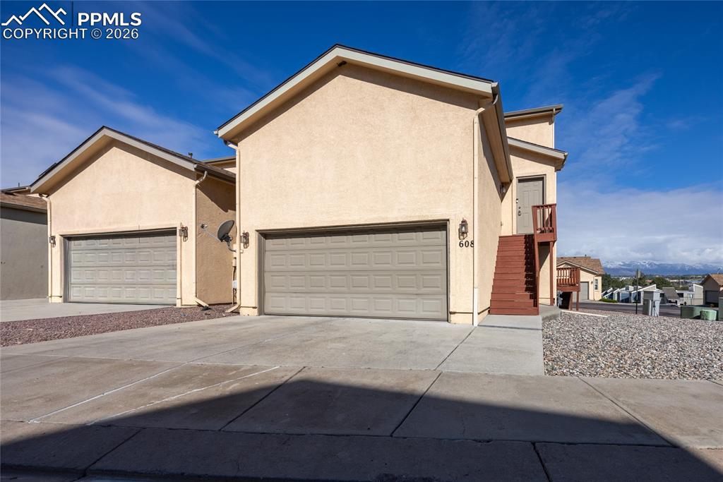 Caption: Exterior featuring stucco siding and a two-car garage