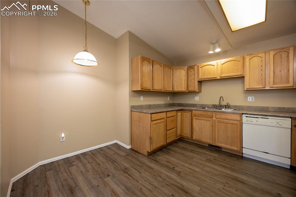Image 13 of 25: Kitchen featuring wood-finish flooring, oak cabinetry, laminate countertops