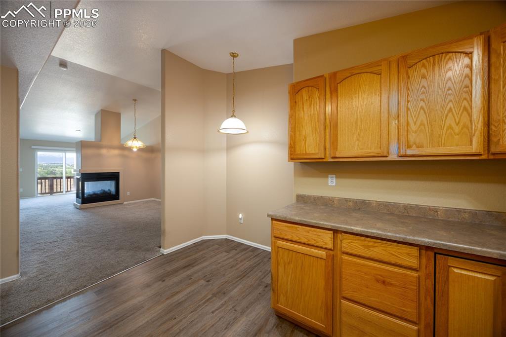 Image 14 of 25: Kitchenette area featuring wood-finish flooring, wood cabinetry with upper 