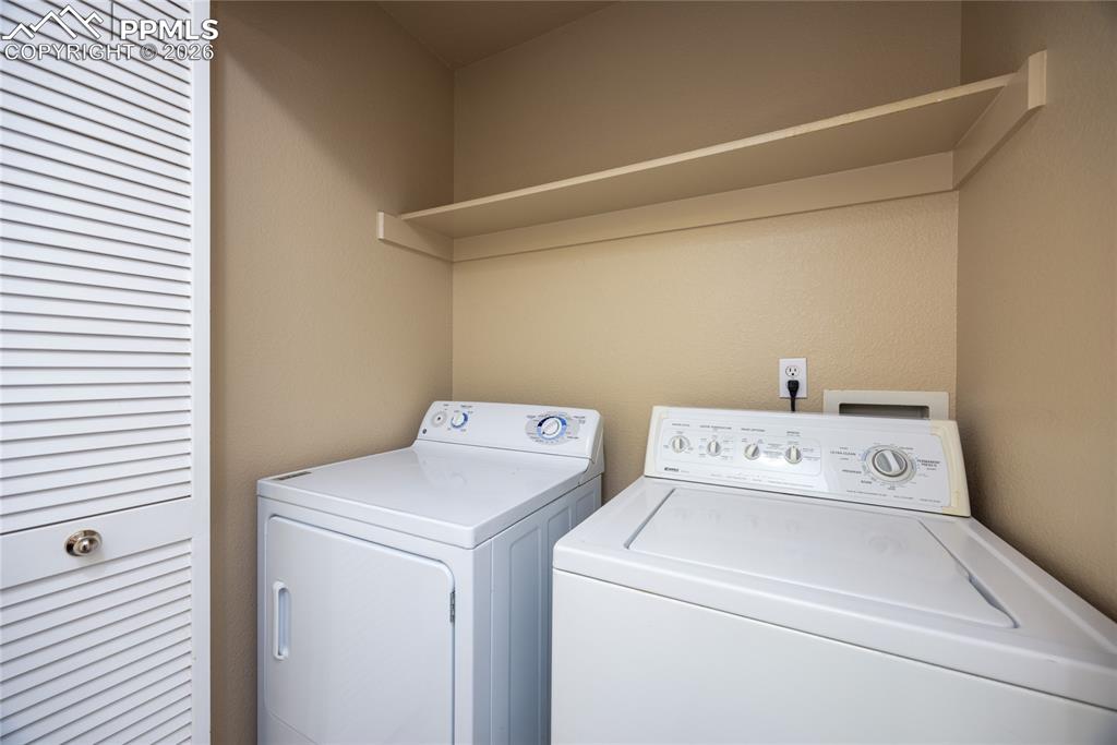 Image 18 of 25: Dedicated laundry area with a top-load washer, front-load dryer, and an ove