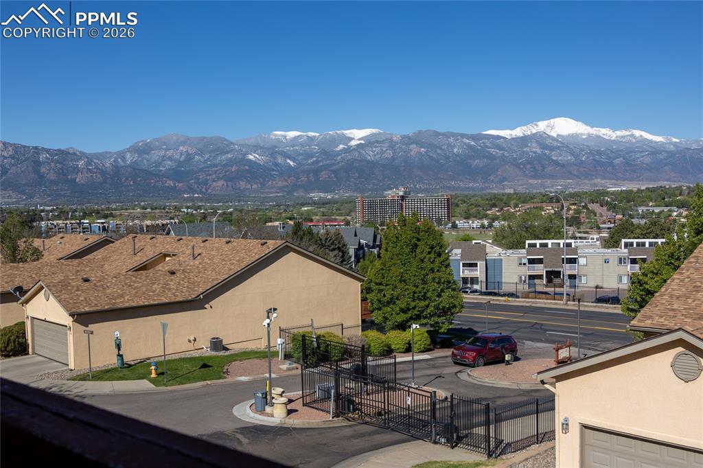Image 2 of 25: Snow-capped mountain range backdrop with a residential community below