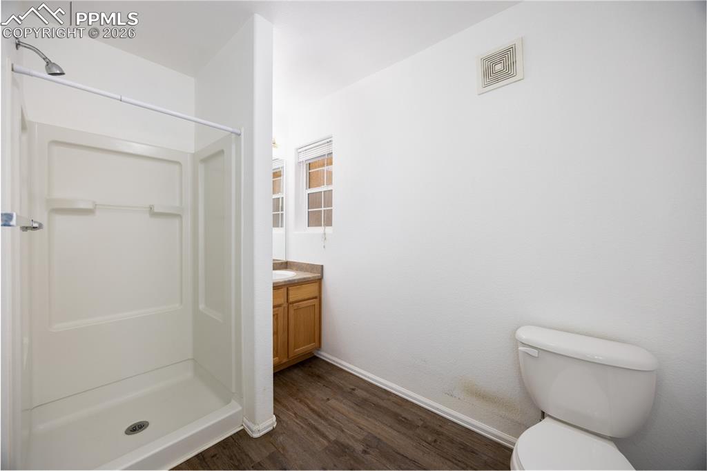 Image 20 of 25: Bathroom featuring a white shower stall, wood-finish flooring, a vanity wit