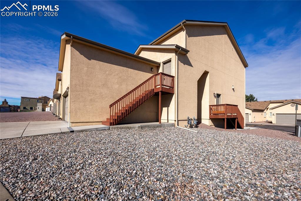 Image 3 of 25: Tan stucco exterior featuring multiple private balconies with wood railings