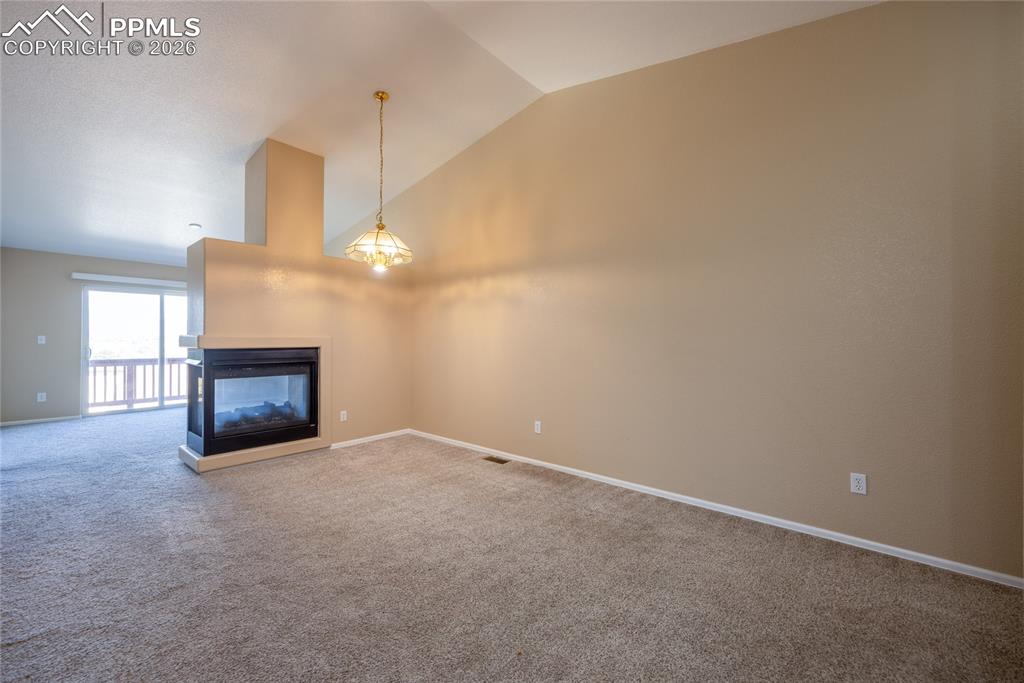 Image 6 of 25: Living area featuring a central fireplace with a black surround and mantel,