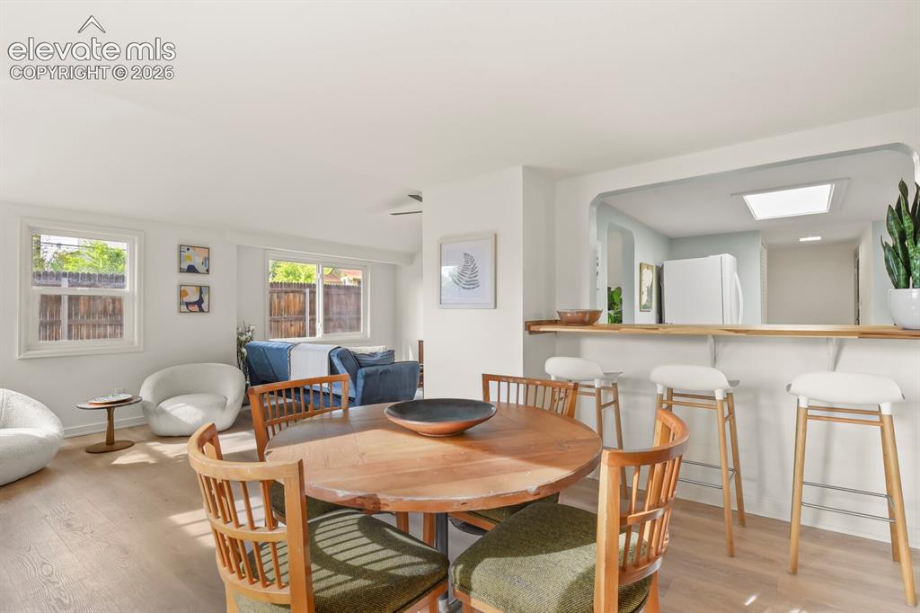 Image 20 of 39: Dining area with original wood burning fireplace and breakfast bar to the k