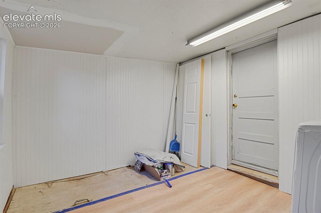 Image 38 of 39: Mud room with trap door to the basement