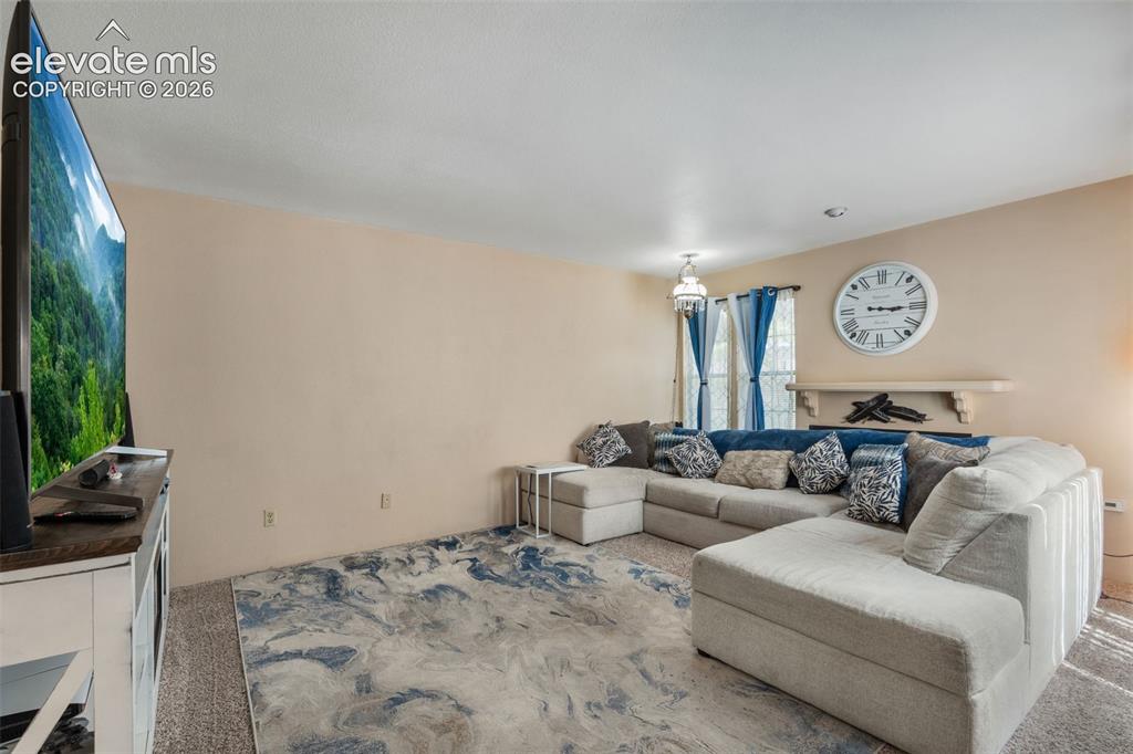 Image 8 of 40: Wood burning fireplace is behind couch