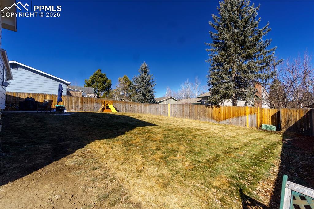 Image 22 of 25: View of yard with a fenced backyard and a playground