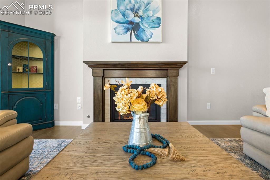 Image 13 of 47: Living area with wood finished floors and a glass covered fireplace