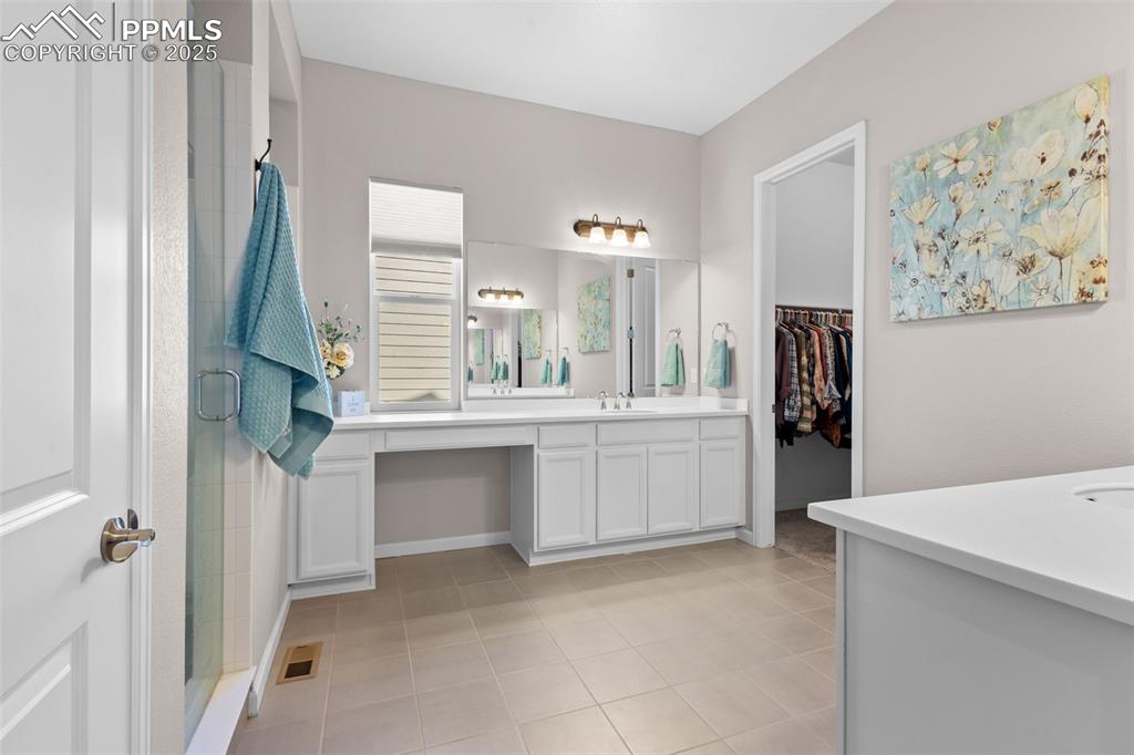 Image 16 of 47: Bathroom featuring vanity, a shower stall, tile patterned floors, and a wal