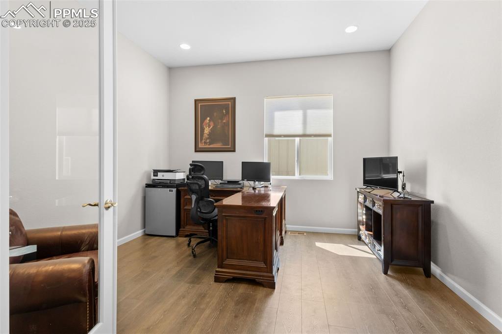 Image 23 of 47: Home office with wood finished floors and recessed lighting