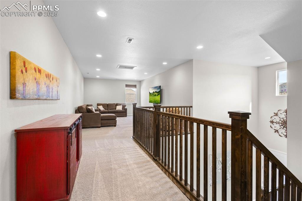 Image 25 of 47: Corridor featuring an upstairs landing, light carpet, and recessed lighting