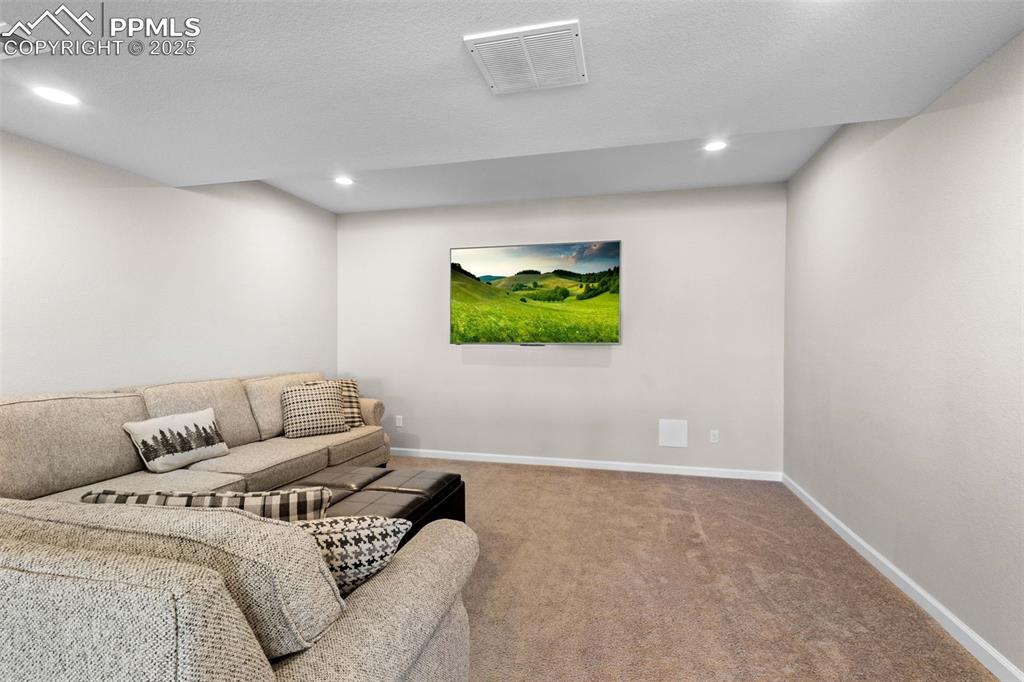 Image 32 of 47: Carpeted living area featuring recessed lighting and a textured ceiling