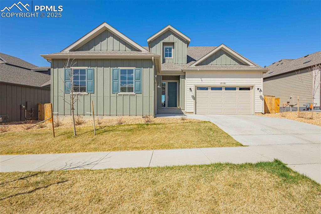 Image 39 of 47: View of front facade featuring board and batten siding, driveway, a garage,