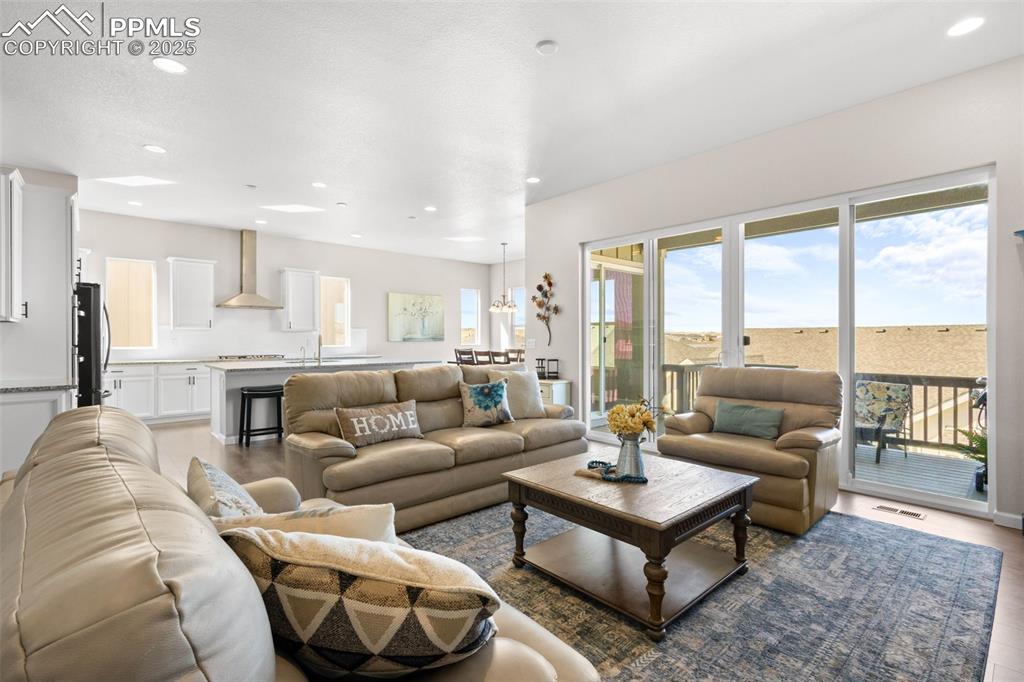 Image 6 of 47: Living room with recessed lighting and wood finished floors